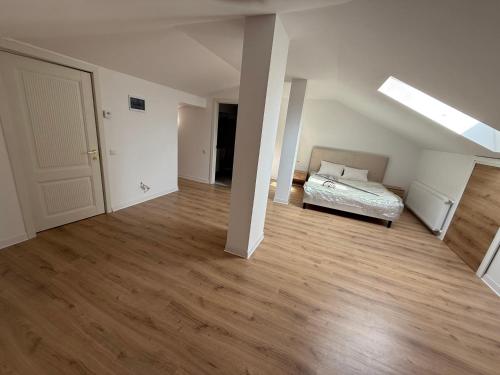 an empty room with a bed and wooden floors at Vila parc 1 in Brăila