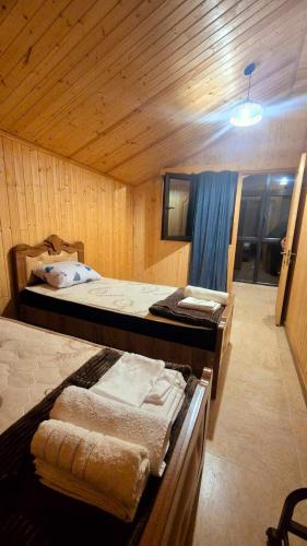 a bedroom with two beds in a wooden room at kotej lazi in Itʼkhvisi