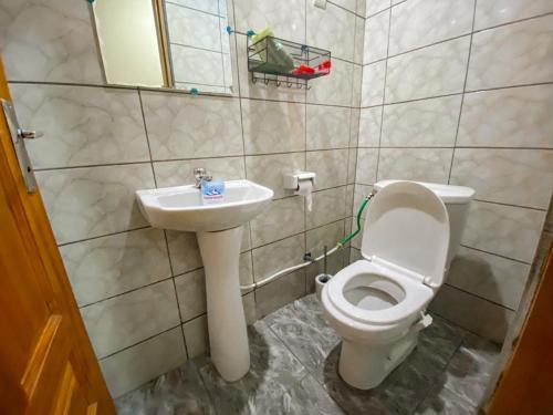 a bathroom with a toilet and a sink at Maison Vacance in Douala