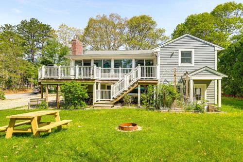 a house with a deck and a picnic table in the yard at 4 Mi to Beach Cape Cod Retreat in Mashpee! in Mashpee