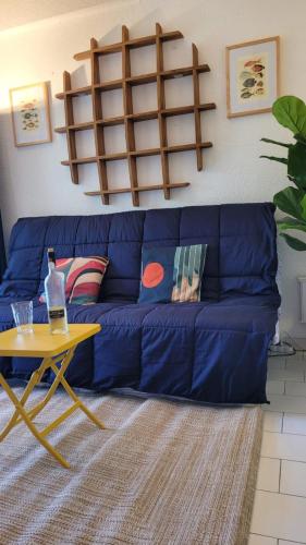 un canapé bleu dans un salon avec une table dans l'établissement House 2p with swimming pool in La Grande-Motte, à La Grande Motte