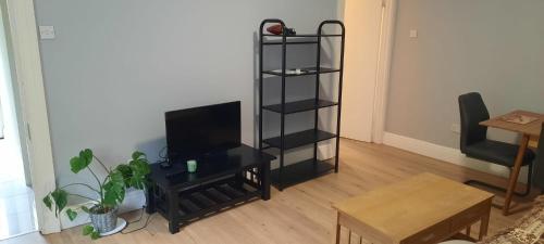 a living room with a television and a table at Lovely 2 Bed Garden Level Apartment Blackrock in Blackrock