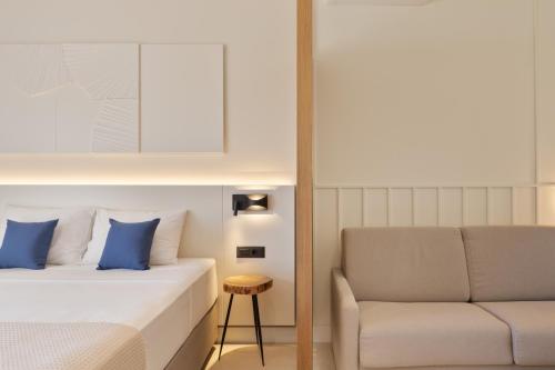 a hotel room with a bed and a chair at Palm Boutique Suites in Pefkohori