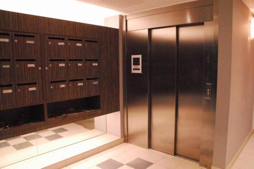 un vestiaire avec un ascenseur métallique dans un immeuble dans l'établissement Le Caroline, à Marseille