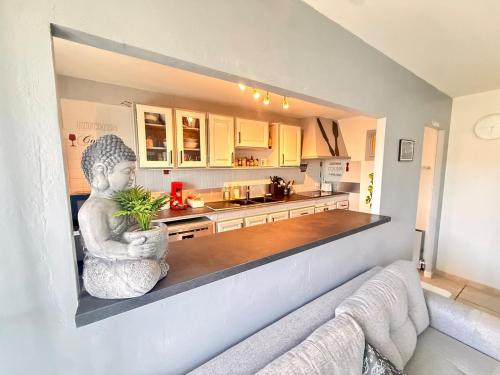 Une statue assise sur un comptoir dans une cuisine dans l'établissement Lamazonite YourHostHelper, à Toulon