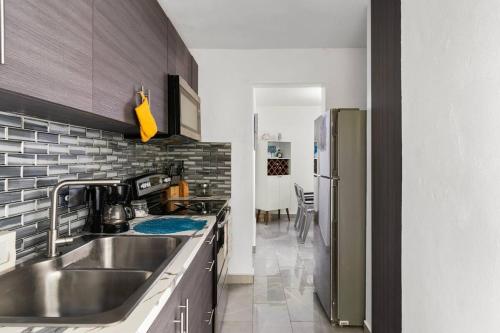 a kitchen with a sink and a refrigerator at Family Home 4 BR Near to the Airport Pool in Carolina