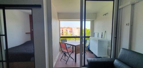 Cette chambre dispose d'un balcon avec une table et un lit. dans l'établissement Studio rénové en 2025 à la marina, au Cap d'Agde