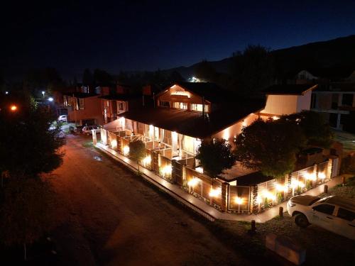 a building lit up at night with lights on it at Cabañas Sublime Bolson in El Bolsón