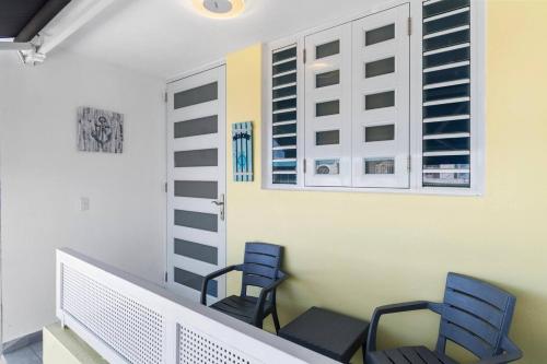 a balcony with two blue chairs and a window at Family Home 4 BR Near to the Airport Pool in Carolina