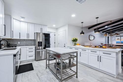 a kitchen with white cabinets and a table in it at Havasu Fun Stay Pool Spa PoolTable KingBed in Lake Havasu City