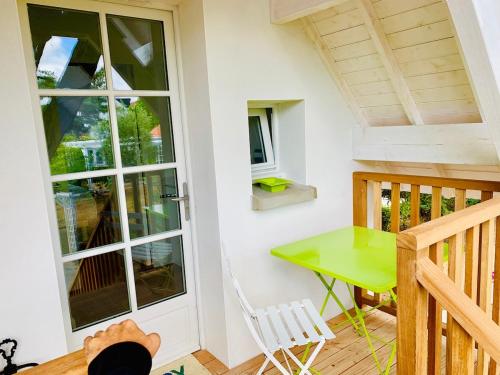 un petit balcon avec une table verte et une chaise dans l'établissement Nice Cottage - Minimum 3 nuits, à La Baule