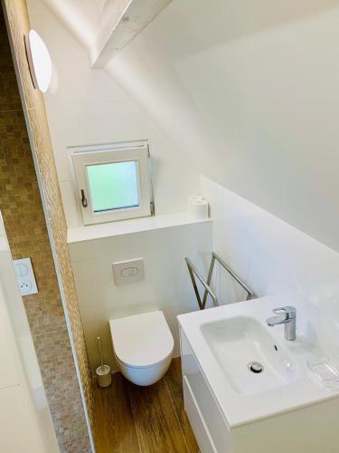 une salle de bain avec des toilettes blanches et un lavabo dans l'établissement Nice Cottage - Minimum 3 nuits, à La Baule