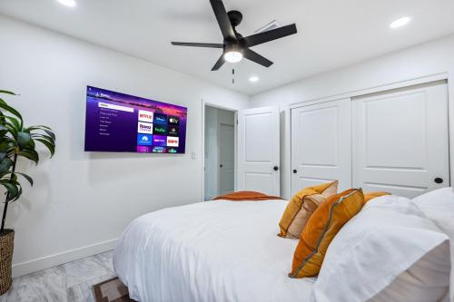 a white bedroom with a bed and a ceiling fan at Havasu Fun Stay Pool Spa PoolTable KingBed in Lake Havasu City