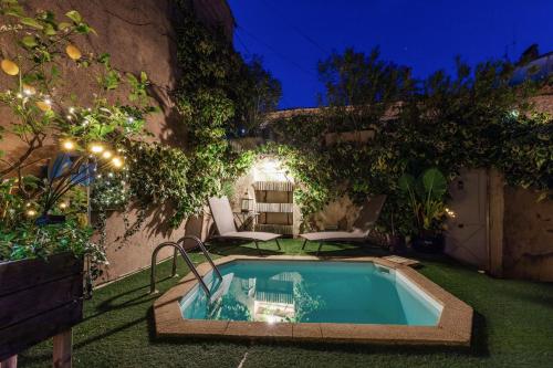 a small swimming pool in a garden at night at L'ORANGERIE Chambres d'hotes de charme in Valros