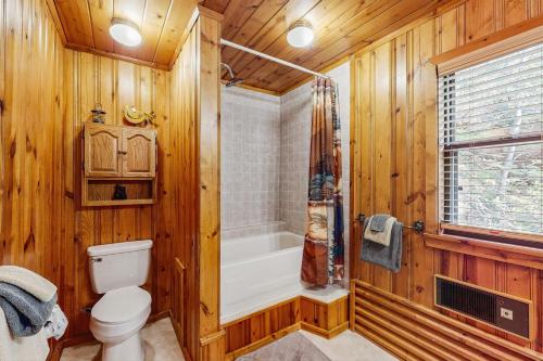 a wooden bathroom with a toilet and a bath tub at DJ Bear Den in Bryson City