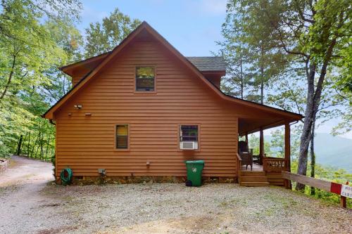 a cabin in the woods with a large porch at DJ Bear Den in Bryson City
