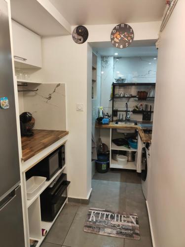 une cuisine avec des armoires blanches et un comptoir dans l'établissement Urban Nest Paris 10, à Paris