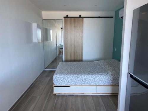 une chambre avec un lit et une porte coulissante en verre dans l'établissement Studio vue mer au Mont des Oiseaux à Hyères, à Hyères