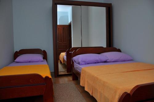 Cette chambre comprend 3 lits et un miroir. dans l'établissement Apartment Bayer, à Herceg-Novi