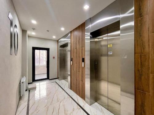 a hallway with a elevator in a building at Auezov City in Almaty