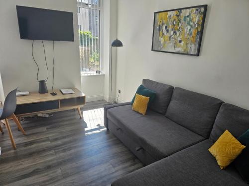 a living room with a couch and a desk at Bright City Apt - King Bed - Parking & Wi-Fi in Dundee