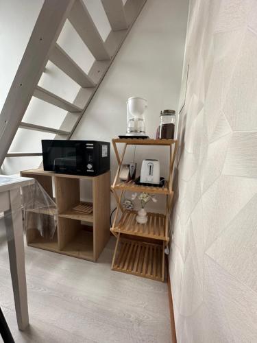 une pièce avec un escalier avec des étagères en bois et un micro-ondes dans l'établissement Appartement Mers Les Bains, à Mers-les-Bains