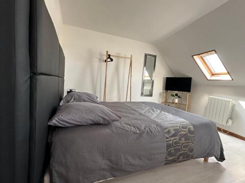 - une chambre dotée d'un grand lit avec des couvertures et des oreillers gris dans l'établissement Appartement Mers Les Bains, à Mers-les-Bains