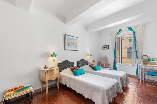 a bedroom with two beds with blue pillows at L'ORANGERIE Chambres d'hotes de charme in Valros