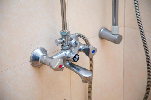 a metal shower faucet in a bathroom at Arusha Hideway Resort in Old Moshi