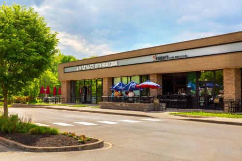 a building with tables and umbrellas outside of it at SpringHill Suites by Marriott Mount Laurel in Mount Laurel