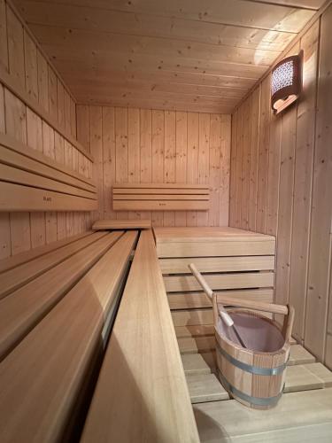 a wooden sauna with a bucket in the middle at La Dila Dolomiti Mountain Lodge in Andalo