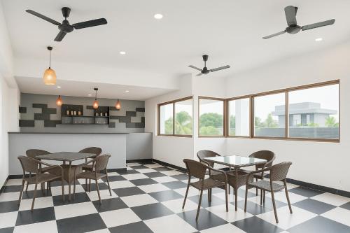 a dining room with tables and chairs on a checkered floor at Resort Three Story Baga GOA in Baga