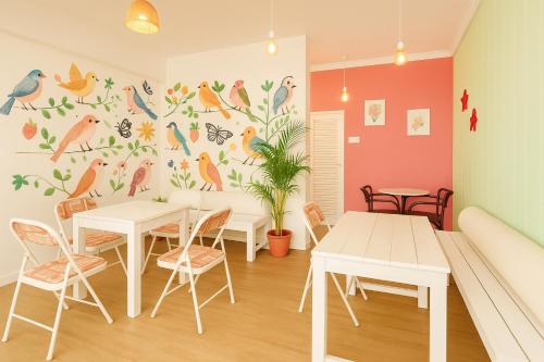 a dining room with a bird mural on the wall at Resort Three Story Baga GOA in Baga