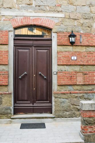 a large wooden door on a brick building at The Clock Tower View Loft in Montecatini Alto