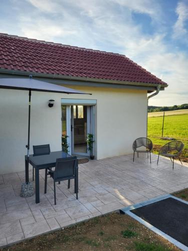 a patio with a table and chairs in front of a house at L'Impasse du Jura in Ménétru-le-Vignoble