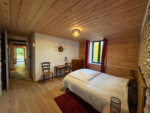 Le refuge d'Yzeron, gite autonome en pleine forêt pour 8 personnes في Yzeron: غرفة نوم بها سرير وطاولة وكراسي