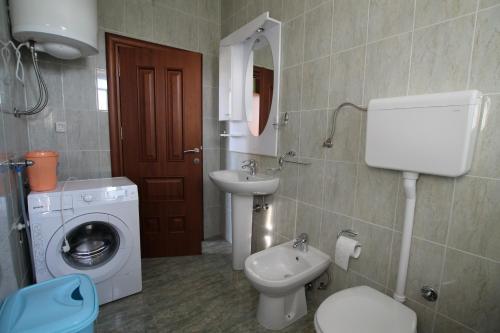 a bathroom with a toilet sink and a washing machine at Apartment Bayer in Herceg-Novi