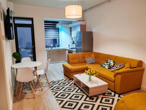 ein Wohnzimmer mit Sofa und Tisch in der Unterkunft Primera Residence Mamaia Nord in Mamaia Nord – Năvodari