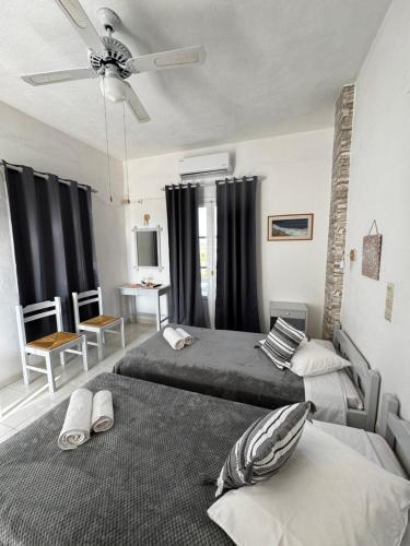 a bedroom with two beds and a ceiling fan at Panagiotis Rooms in Naousa