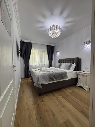 a bedroom with a large bed and a chandelier at Vibe Residence Suceava in Suceava