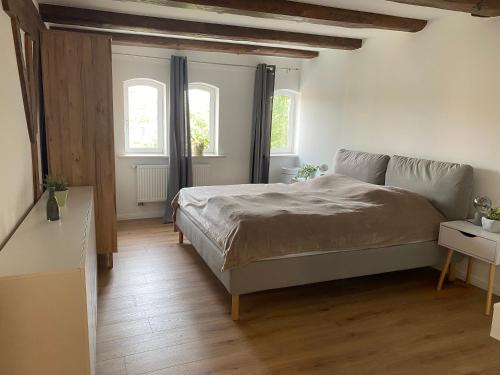 a bedroom with a bed and two windows at Ferienwohnung Altstadt Frankenstraße in Stralsund