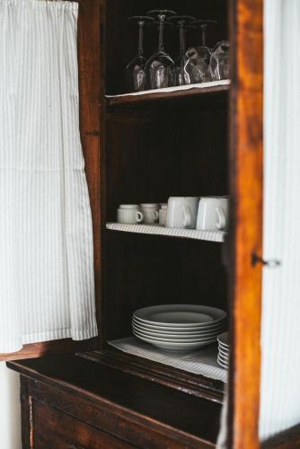 a cabinet with plates and cups on a shelf at The Clock Tower View Loft in Montecatini Alto