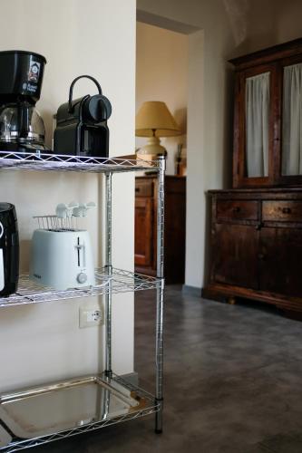 a room with a shelf with a microwave and a table at The Clock Tower View Loft in Montecatini Alto
