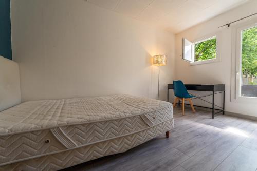 une chambre avec un lit, un bureau et une fenêtre dans l'établissement L'Ecrin Vert - Maison 6 Chambres 12 Pers à Bdx, à Gradignan