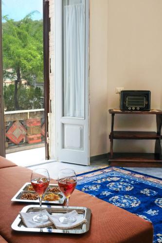 a table with two glasses of wine and a plate of food at The Clock Tower View Loft in Montecatini Alto