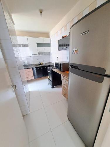 a kitchen with a stainless steel refrigerator in it at Comfortable apartment in Aracaju in Aracaju