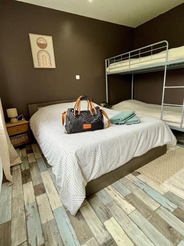 - un sac assise sur un lit dans une chambre dans l'établissement La Pause Bain & Nature, à Incheville