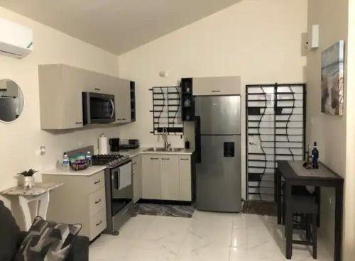 a kitchen with white cabinets and a refrigerator at Phoenix park VD in Portmore