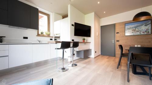 Una cocina con gabinetes blancos y una mesa y sillas. en Italianway - Roma 38, en Bormio