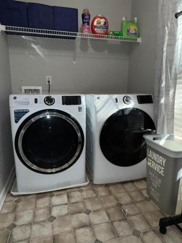 two washing machines sitting next to each other in a laundry room at Spacious 4BR Villa Getaway near Atlanta in Douglasville